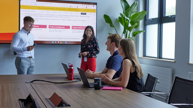 students giving a presentation in a meeting rom