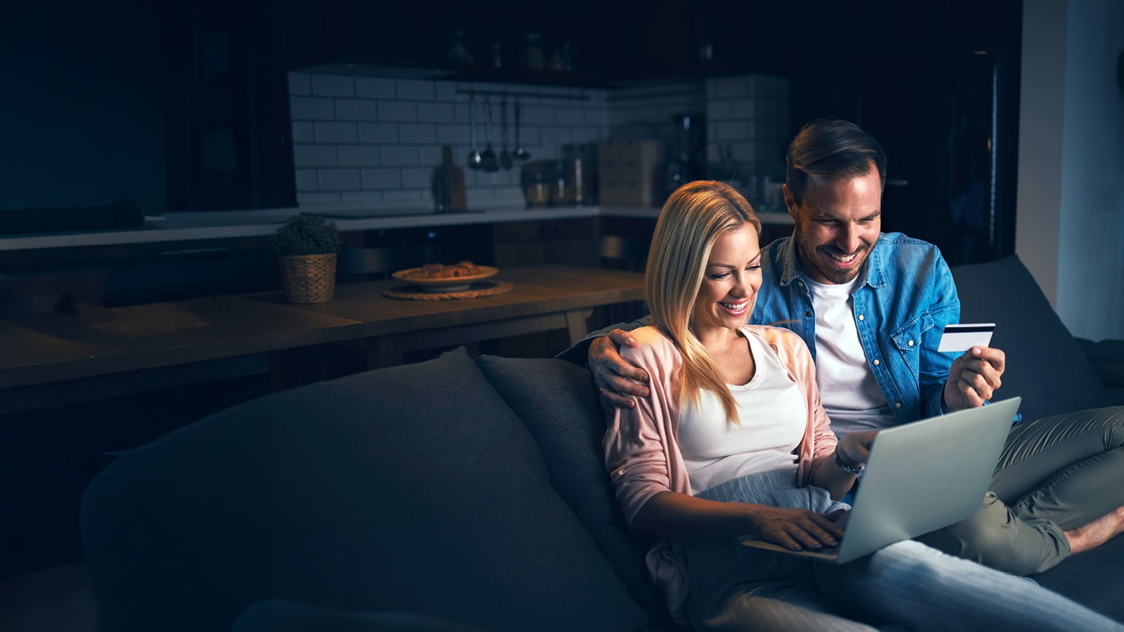 A couple shopping online using a laptop 