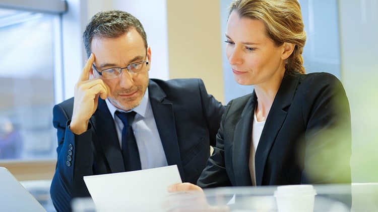 Two people discussing a file