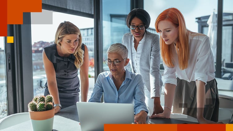 Four people gathered around a laptop